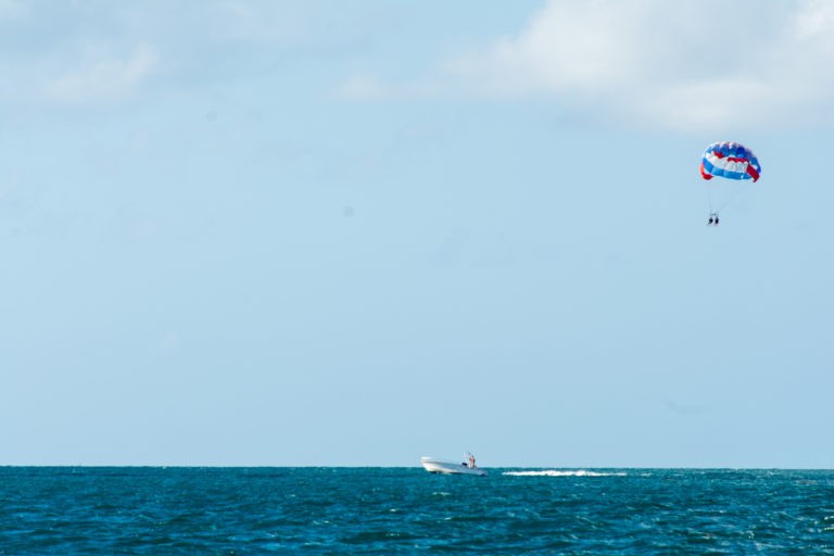 wide shot of parasailers being towed by speedboat