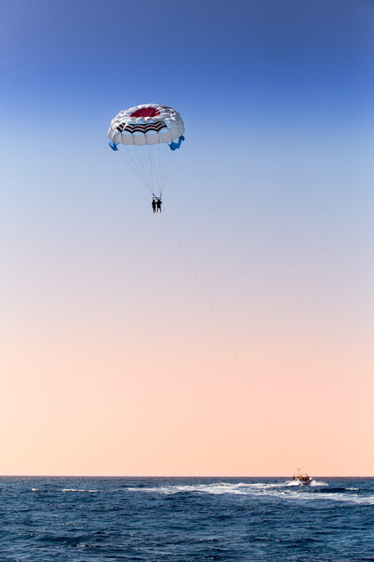 parasailing over blue sea and with clear skies